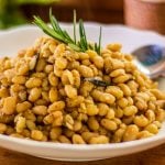 A very basic white bean recipe that’s healthy and full of fibre. This will adapt to any white bean recipe but the cannellini kidney shape bean seems to hold up its shape a lot better. It’s a basic dish that’s very tasty, you need to use a good quality first pressed virgin olive oil for great results. Use freshly cracked pepper and if you can, fresh rosemary. It’s best to salt last so they retain their shape. Older beans will take longer to cook, 30 to 45 minutes, fresher beans can cook as quickly as 20 minutes. The bicarbonate of soda adds an alkaline that helps the bean keep their shape and speeds up the cooking process. This step is optional.