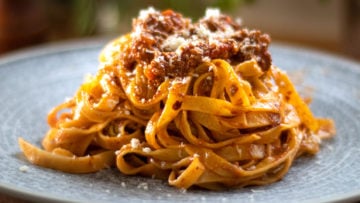 Bolognese sauce or Ragu alla Bolognese, is an Italian meat-based sauce for pasta which originated in Bologna in Northern Italy. Also known as Bolognese Ragu. This version is the closest thing to being the authentic recipe, however there can still be many variations. I don’t think there truly is an authentic version, but this is so close! Some use butter, others olive oil. For Ragu, I personally prefer olive oil. Some also add cream at the end, I don’t think it needs it, the milk does the job. The secret of course is in the sauce, it has to be cooked for a long time, the longer the better. This breaks down the meat fibres which thickens and intensifies the sauce. In the days they used to cook this 5 to 6 hours as meat was tough. Today 2 to 3 hours is plenty. Traditionally the meat is not minced but chopped using a knife. If you don’t have pancetta, you could use pork mince also. Some parts of Italy may also use butter instead of olive oil, I prefer virgin olive oil for this. Milk is also added towards the end of the cooking process, to dampen he acidy of the tomato. Cream is an optional extra, and usually used for dryer style eggless pasta. Now I know, spaghetti Bolognese sounds like an authentic Italian dish, but in fact it’s never seen in Bologna. In fact, you will never find it in Italy or at least I certainly haven’t. You will however find it in Europe, US, Australia, and some other countries. It’s also known as spag bowl, which is a terrible name, so please don’t ever use the name unless you’re a young teenager!