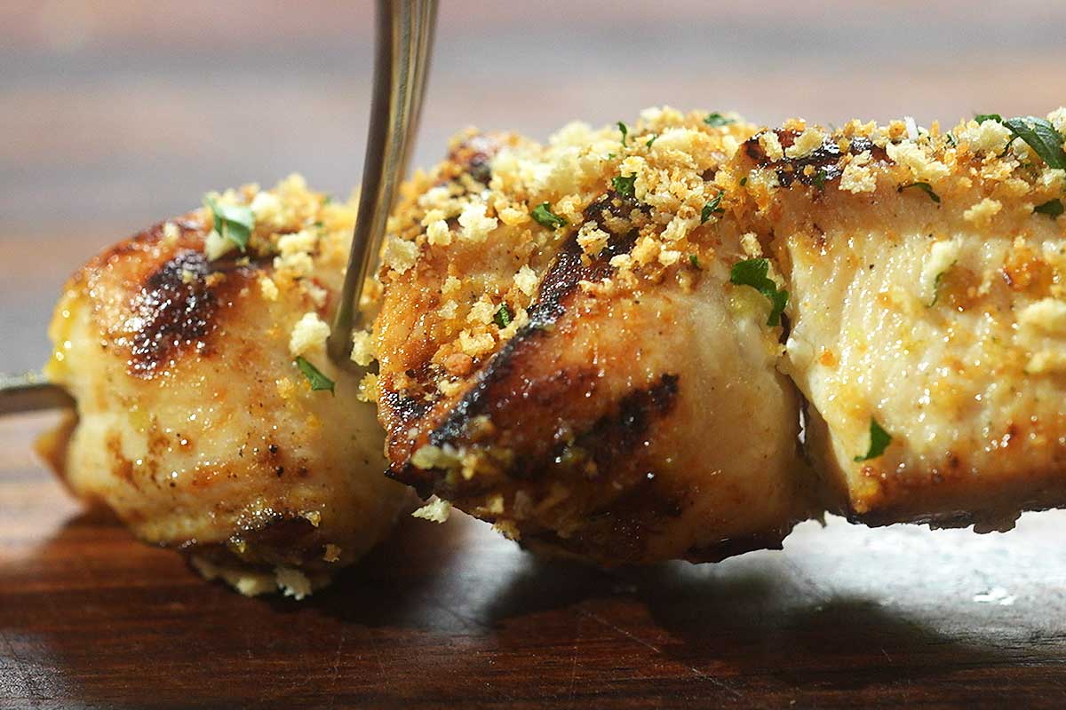 Close up of crispy golden chicken spiedini crust with garlic butter