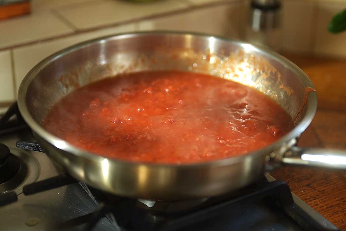 Slow-cooked aglione tomato sauce simmering with garlic melting into it