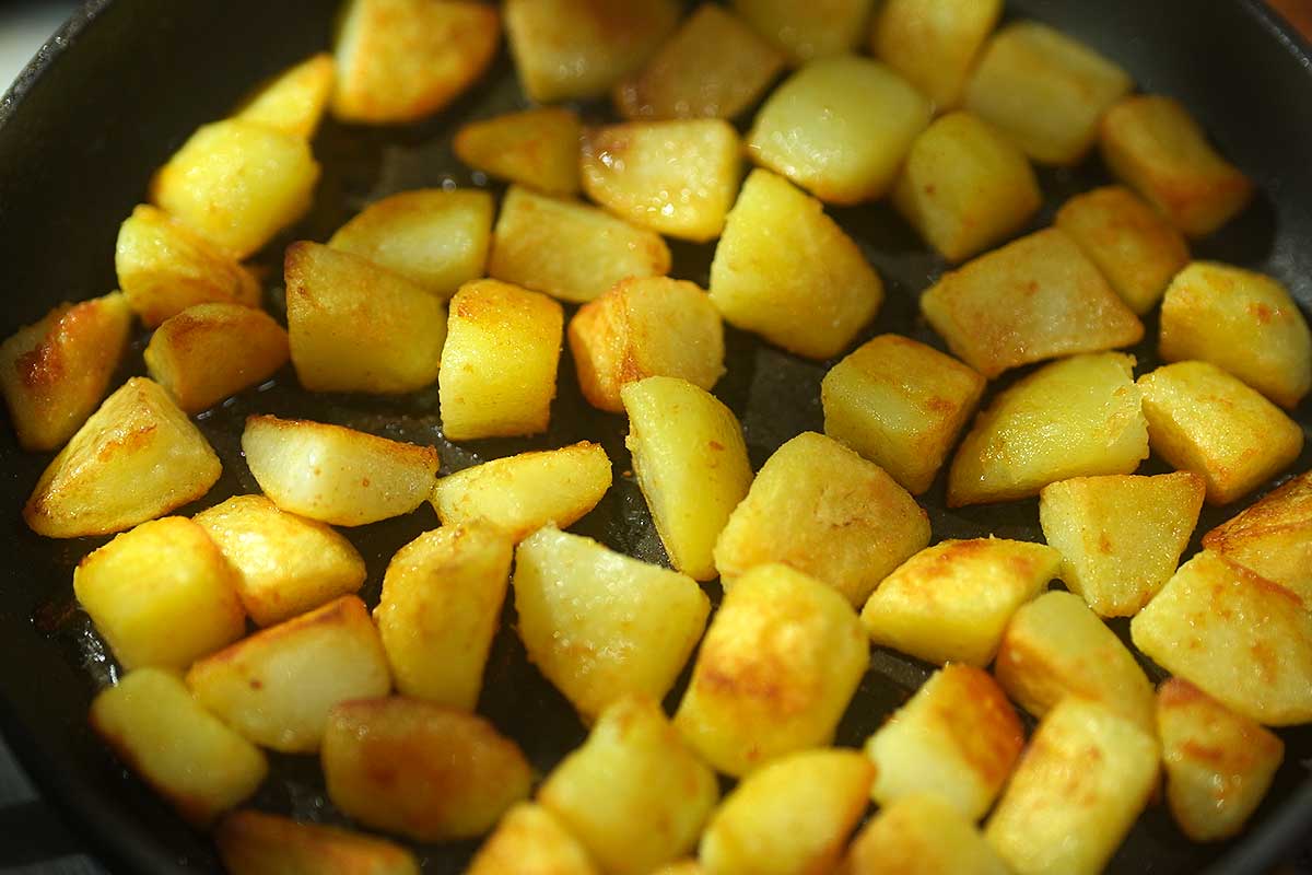Potatoes frying golden in a hot frying pan