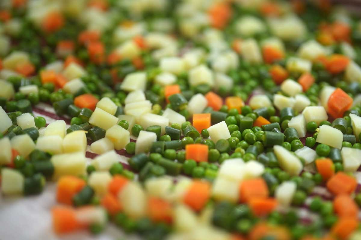 Overhead shot of the diced macédoine vegetables laid out separately before mixing, showing the even ¼-inch dice