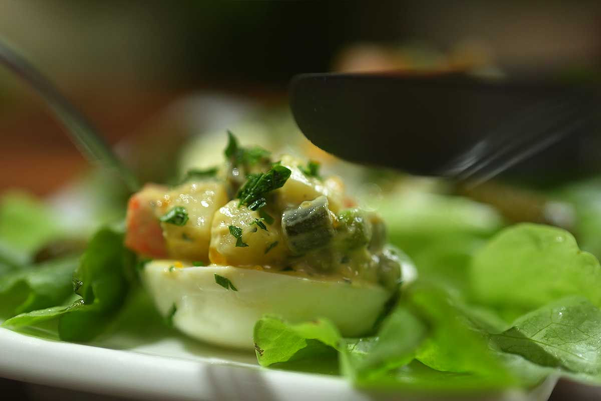 platter of stuffed eggs on lettuce leaves, garnished with parsley