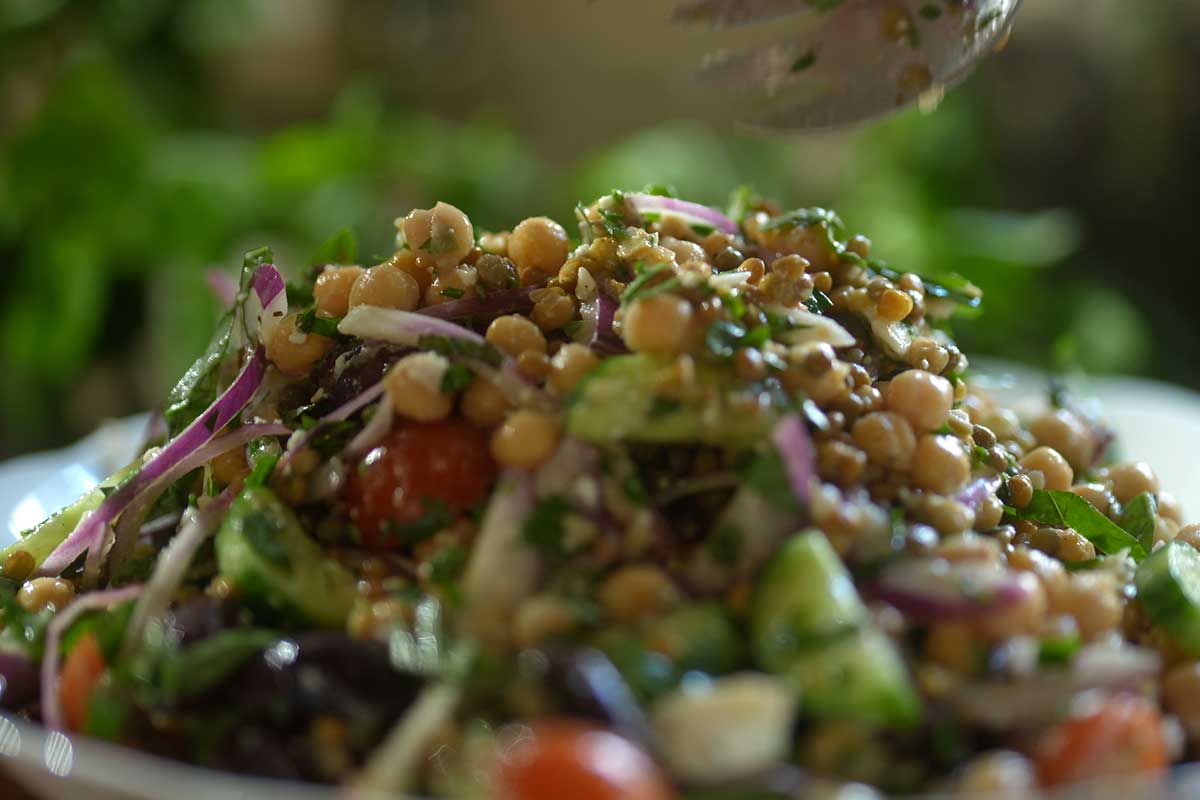 Close up of chickpeas lentils feta and olives in lemony oregano dressing