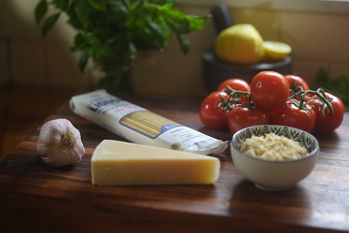 Overhead shot of the raw sauce ingredients, tomatoes, almonds, basil and garlic, arranged before blending