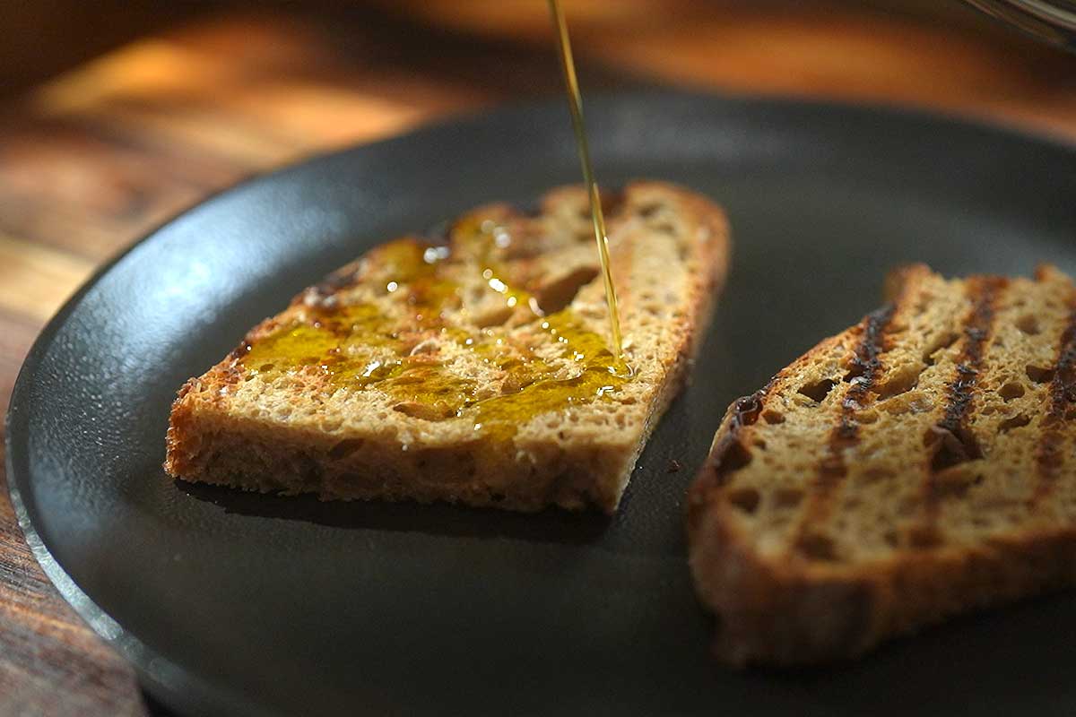 Drizzling olive oil over the a toast