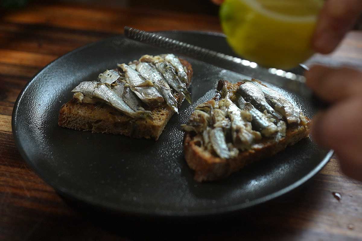 Close up cross section shot showing the whole sardine fillets over the toast