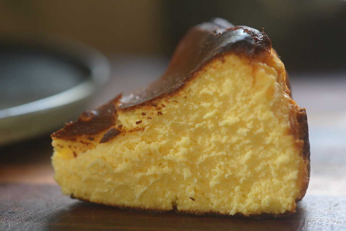 A slice being cut, showing the creamy interior against the dark top