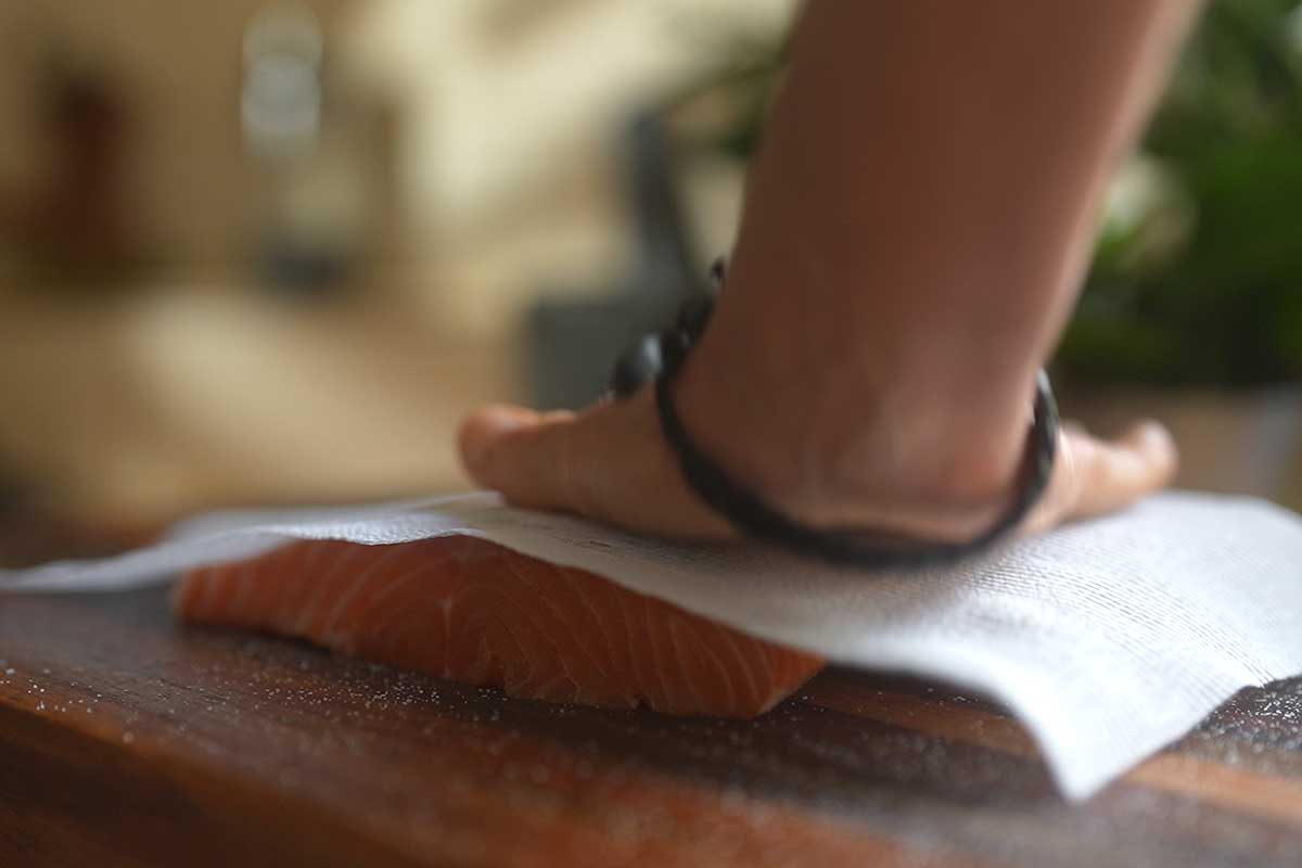 Patting the salmon skin dry with paper towel