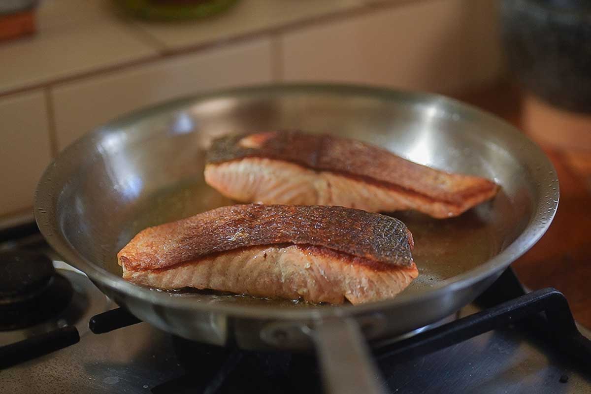 Close-up of the deep golden skin as the salmon is turned over