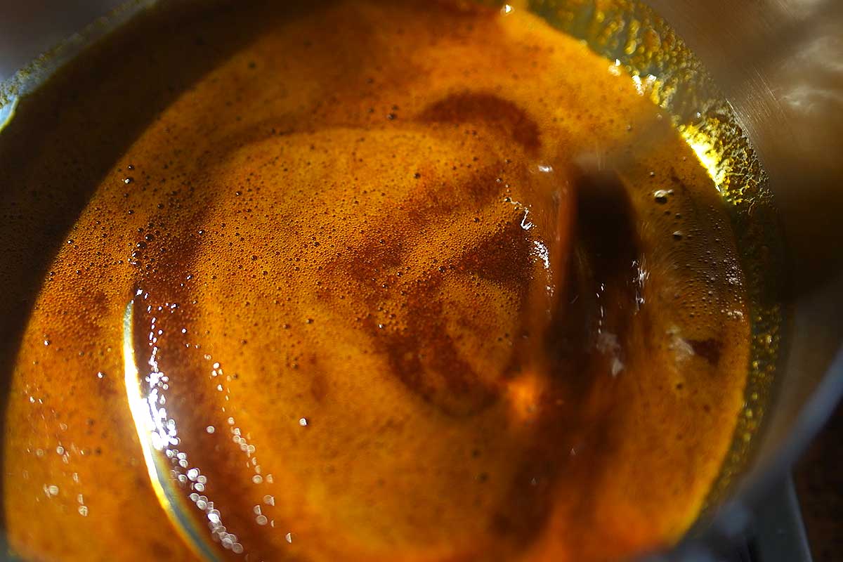 Smoked paprika being stirred into warm olive oil off the heat