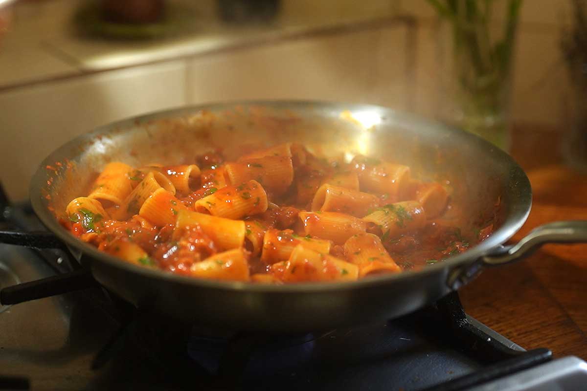 Red wine vinegar and chopped parsley going into the pasta for the final toss