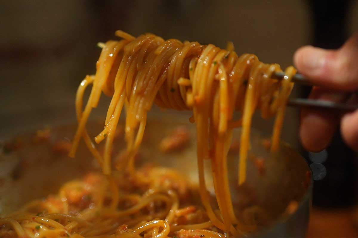 Close up on the finished sauce clinging to the spaghetti