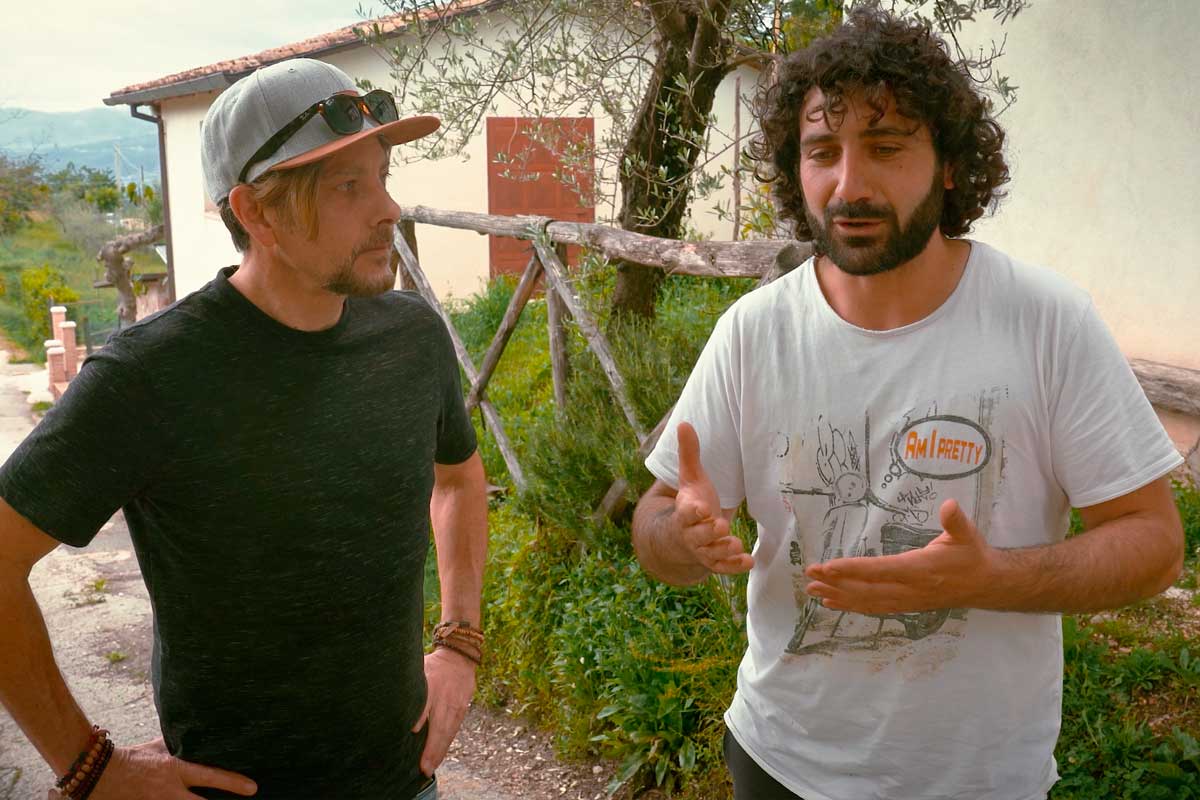 Chef Joel Mielle speaking to an olive oil producer in Italy