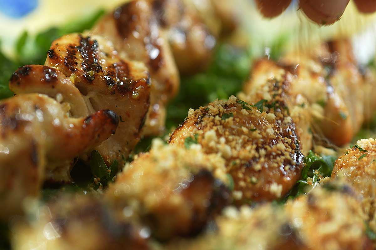 Toasted panko parmesan crumb scattered over hot buttery chicken skewers