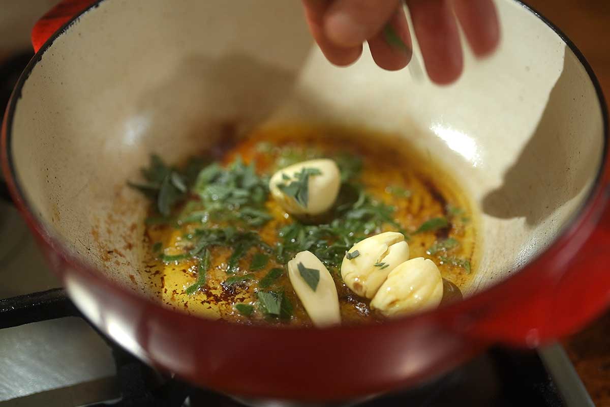 Garlic and fresh sage leaves gently sizzling in extra virgin olive oil