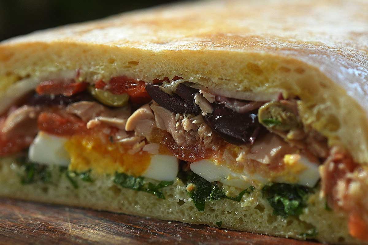 Close up cross section of pressed Pan Bagnat showing compressed unified layers