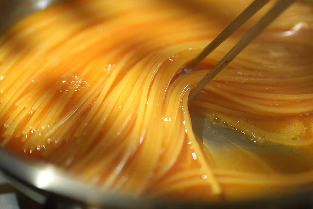Spaghetti cooking directly in tomato broth risotto style thickening slowly