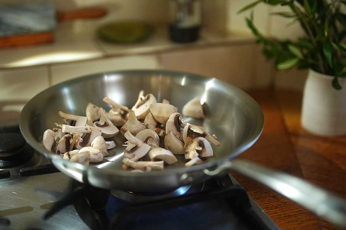 Mushrooms toasting dry in hot pan without oil starting to brown