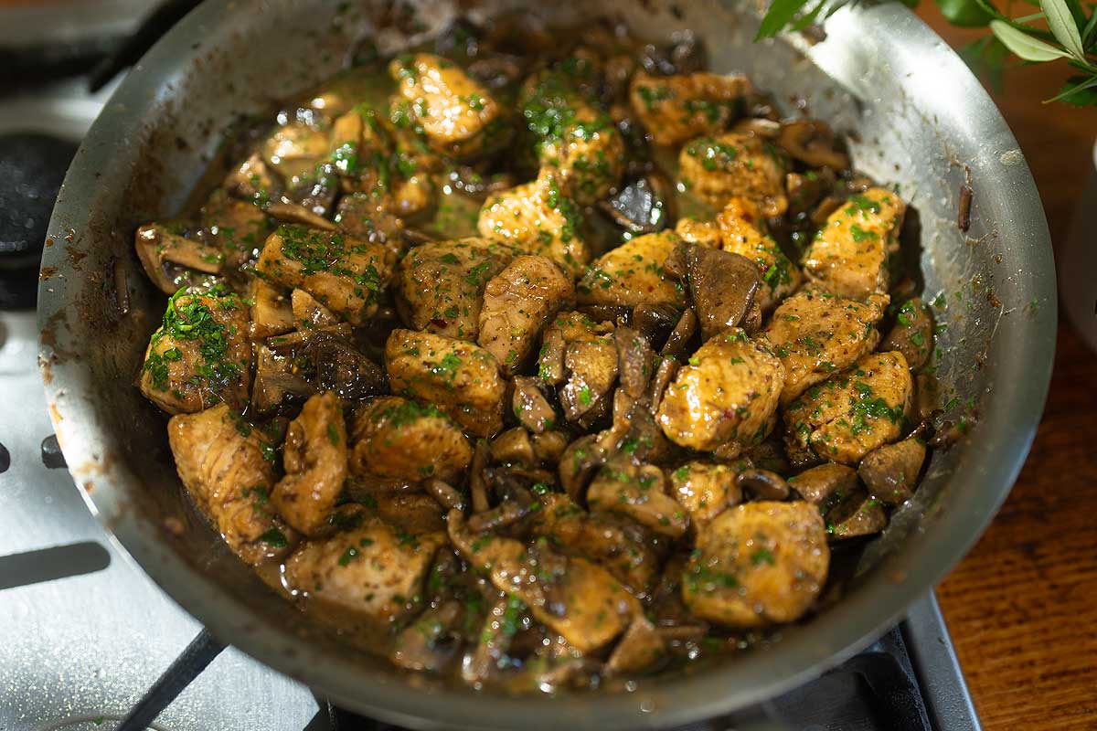 Pollo ai Funghi finished in pan glossy sauce with parsley ready to serve